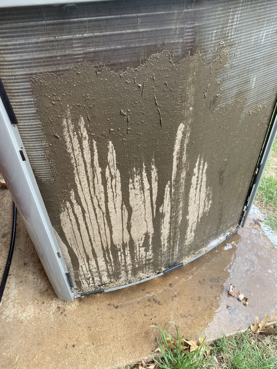 Outdoor AC condenser coil caked with mud and debris during a coil cleaning by a Monarch Heating & Air technician